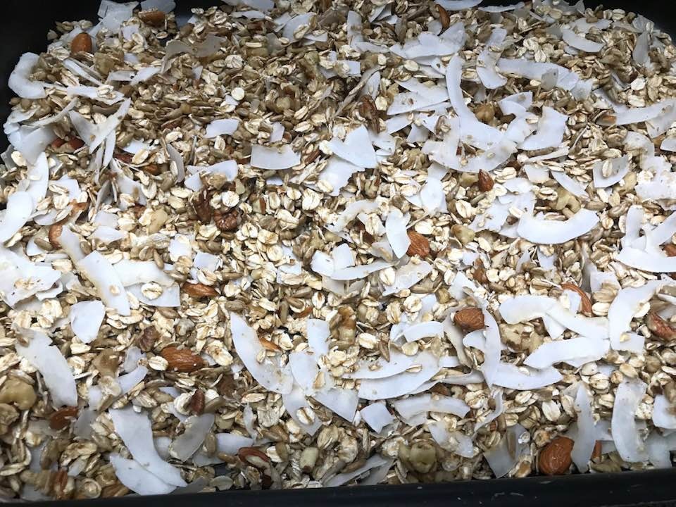 A tray of homemaade roasted granola with assortment of the ingredients